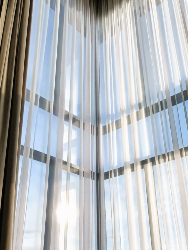 Okno wysokie z zaslonami i firanami